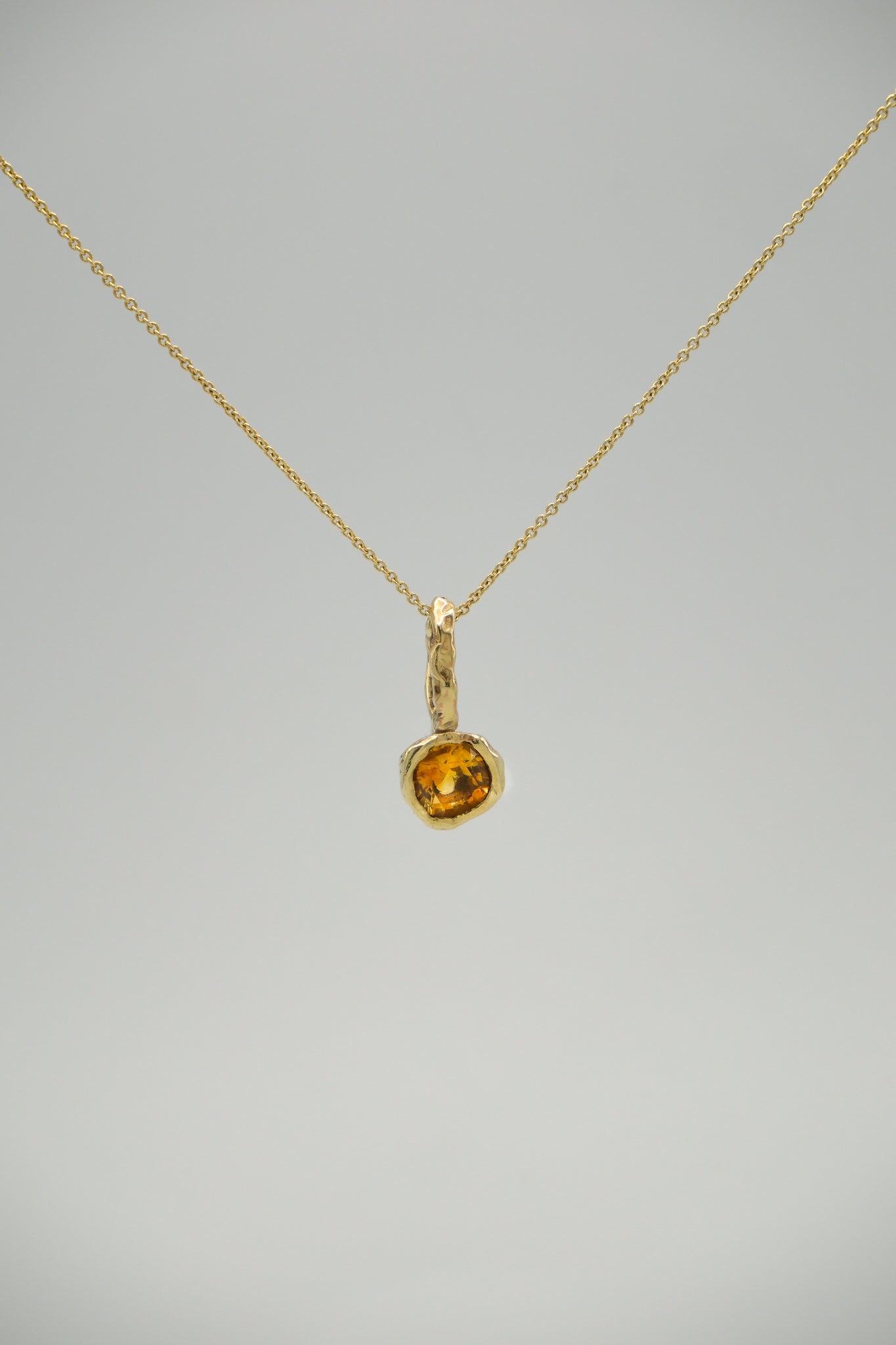 Orange citrine stone pendant from Sol and Mani's June collection, featuring a polished, teardrop-shaped design.