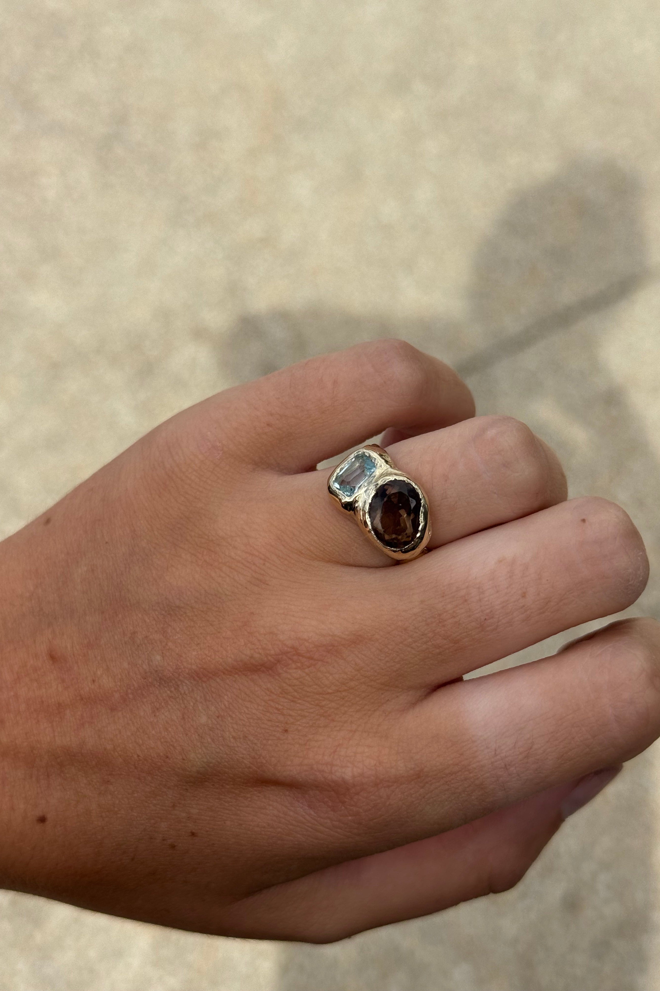 Sol and Mani Daydream ring featuring smoky brown quartz and blue topaz gemstones in an elegant gold band.