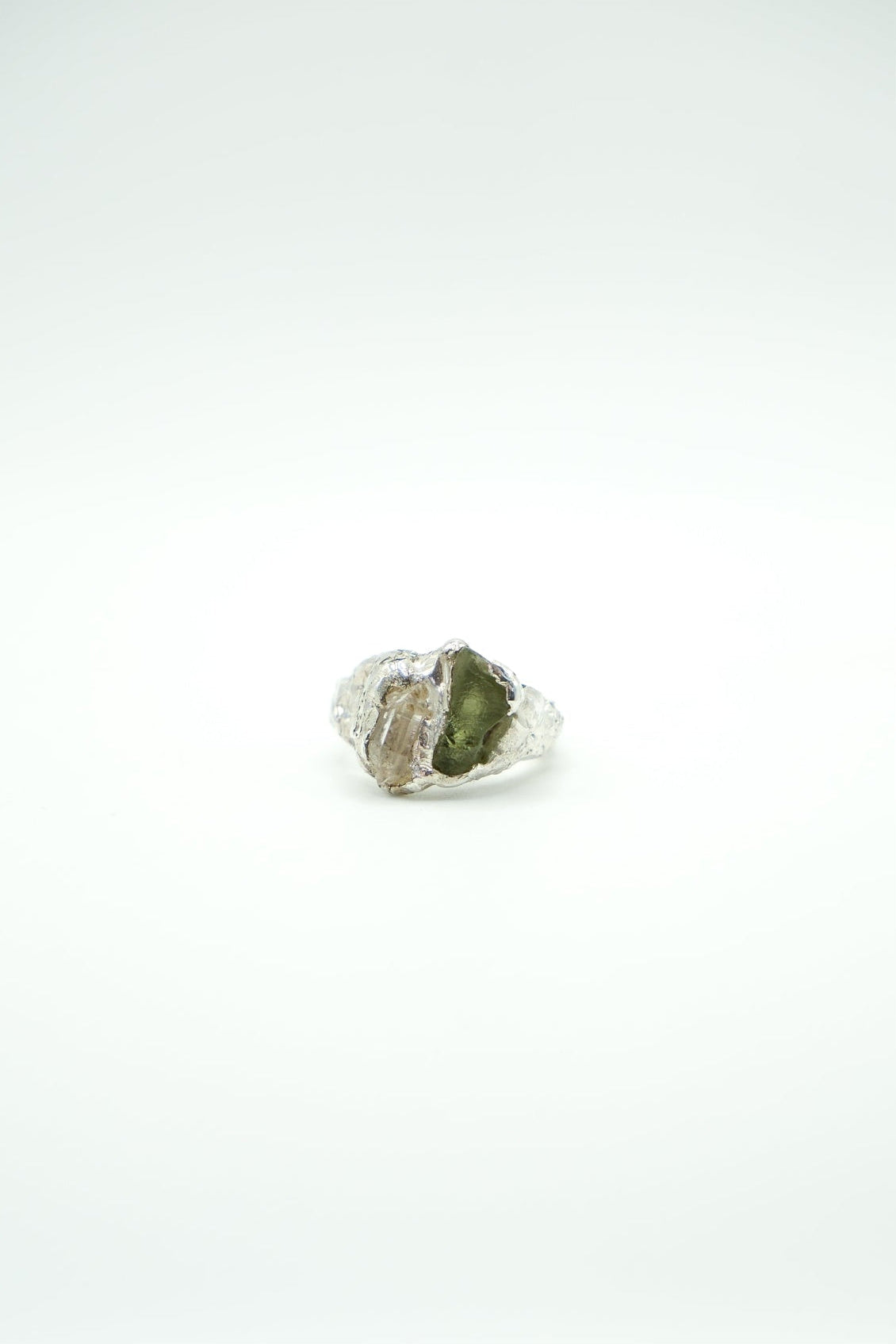 Silver ring with a green stone on a white background