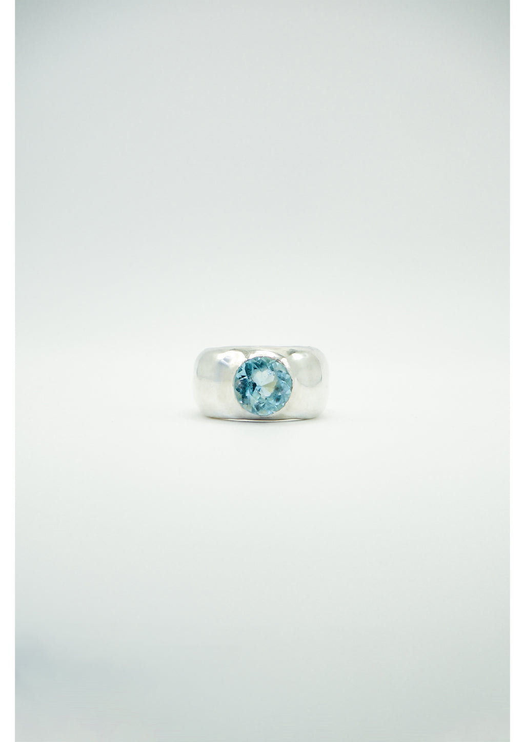 Large silver ring by Sol and Mani featuring an oval blue topaz stone set in a detailed band.