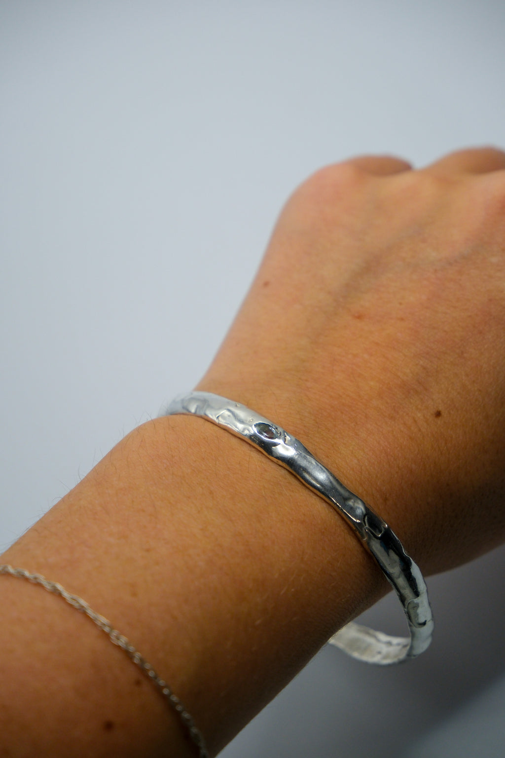 Elegant Sol and Mani moon bangle featuring a sleek silver crescent moon design on a delicate gold band.