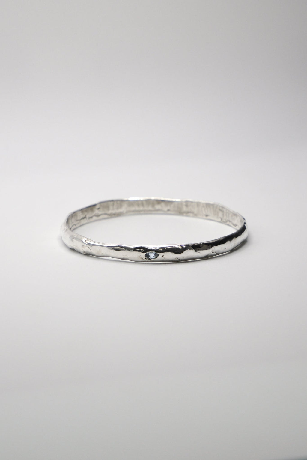 Sol and Mani Moon Bangle featuring a sleek, silver-toned design with a moon-shaped centerpiece and smooth, rounded band.