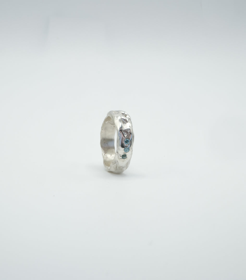 Sol and Mani Little Flower ring featuring three blue stones, elegant jewelry piece with intricate floral design and sparkling gemstones.