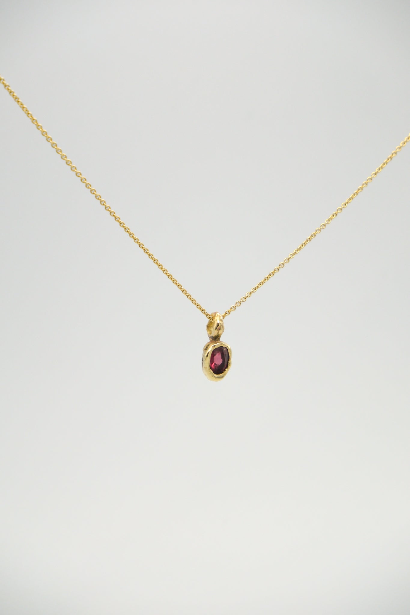 Sol and Mani Rhodolite Garnet Starling Pendant featuring a vibrant red gemstone and intricate metalwork design.